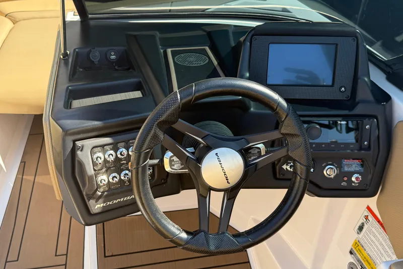 Slide: The Image of 2021 Moomba Max boat dashboard with steering wheel and control panel. - 11