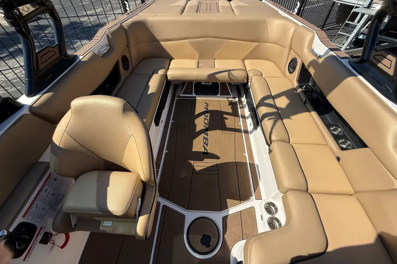 Slide: The Image of 2021 Moomba Max boat interior with tan seating and wood flooring. - 12