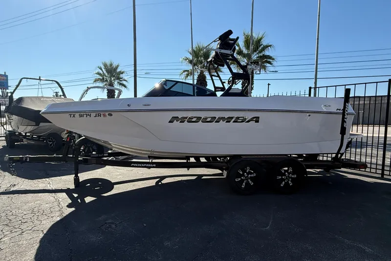 Slide: The Image of 2021 Moomba Max boat on trailer, parked outdoors with palm trees in background. - 4