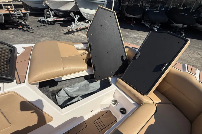 Slide: The Image of 2021 Moomba Max boat interior with open storage compartments and tan seating. - 8