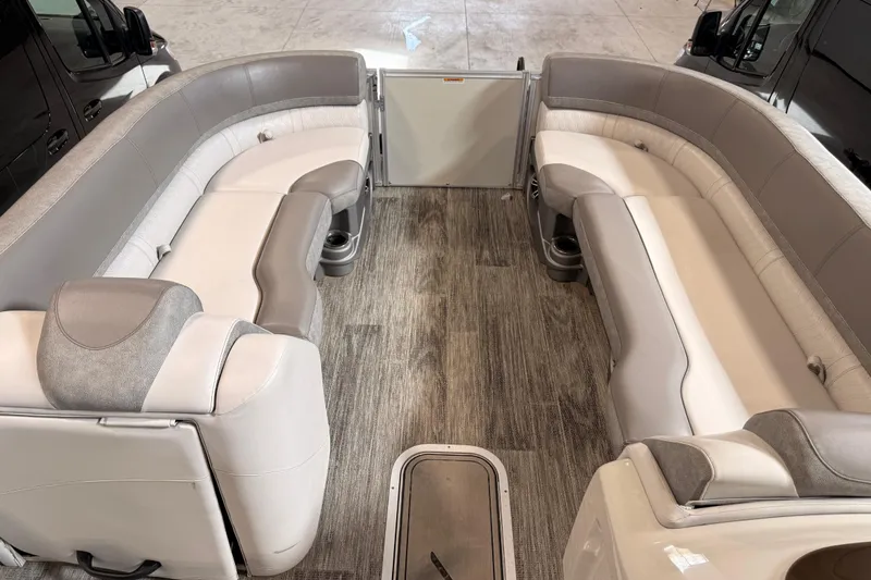 Slide: The Image of 2023 Avalon Catalina Platinum Rear J Lounge boat interior with luxurious seating and wood-style flooring. - 13