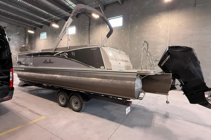 Slide: The Image of 2023 Avalon Catalina Platinum Rear J Lounge boat in a warehouse setting. - 2