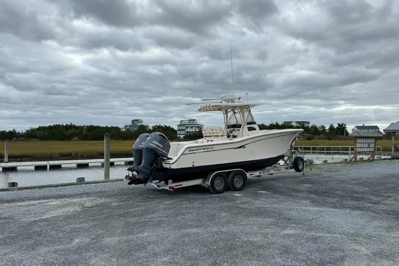 The Image of 2012 Grady-White Canyon 271 boat on trailer, displayed outdoors at Cedar Creek Marine. - 1