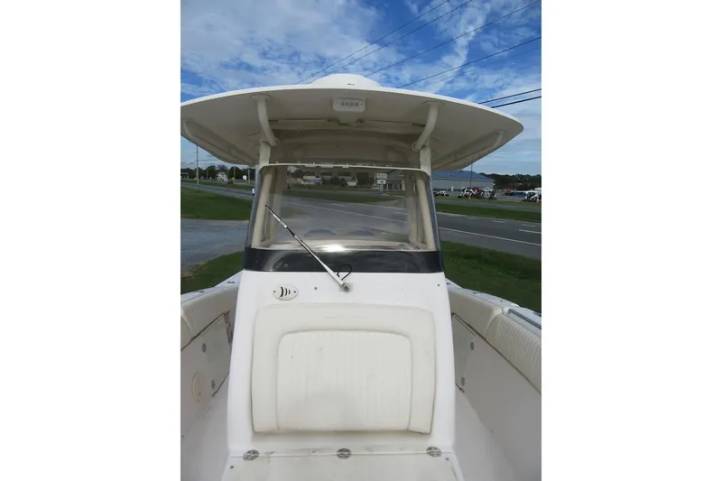 Slide: The Image of 2012 Grady-White Canyon 271 boat, center console view, under a clear blue sky. - 16