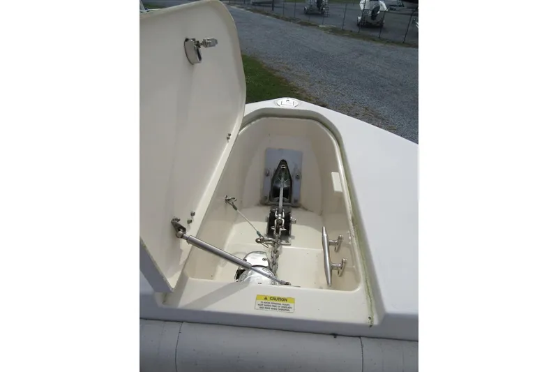 Slide: The Image of 2012 Grady-White Canyon 271 anchor locker with open hatch, showcasing anchor mechanism. - 9