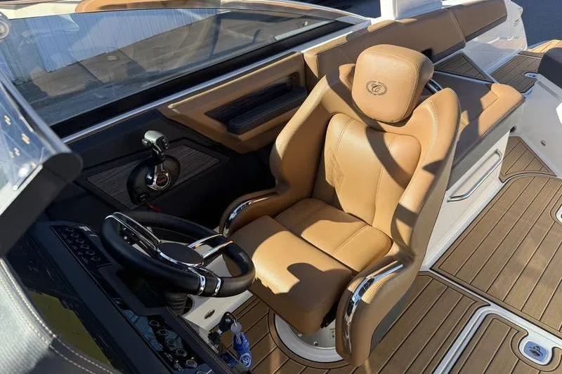 Slide: The Image of Luxurious 2022 Cobalt R6 boat interior with tan leather captain's seat and sleek steering wheel. - 25