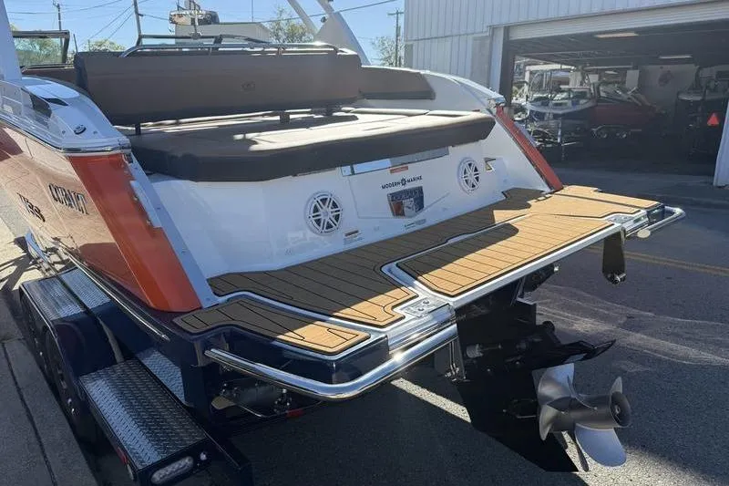 Slide: The Image of 2022 Cobalt R6 boat rear view with swim platform and propeller, parked outside a garage. - 32