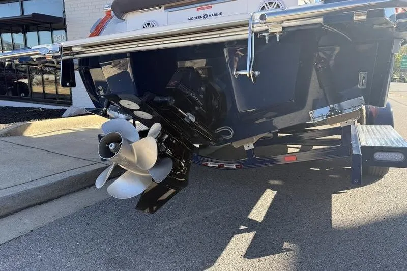 Slide: The Image of 2022 Cobalt R6 boat stern with propeller, parked on a trailer in sunlight. - 34
