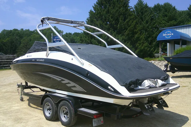 Slide: The Image of 2010 Yamaha Boats 242 Limited S on trailer, covered, parked outdoors. - 28