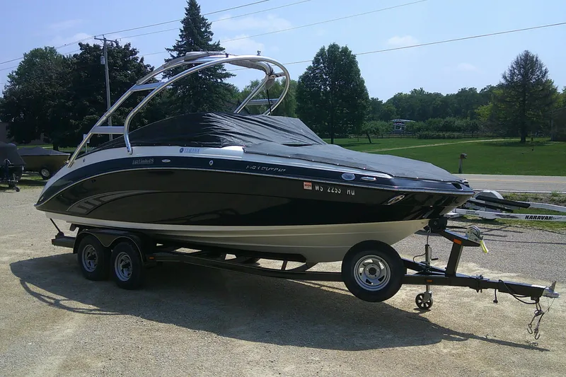 Slide: The Image of 2010 Yamaha Boats 242 Limited S on trailer, covered, parked outdoors. - 29