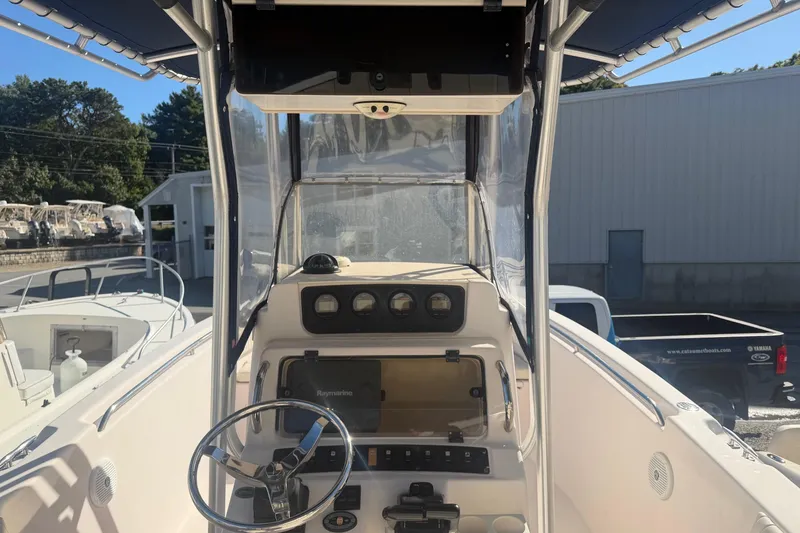 Slide: The Image of 2005 Grady-White Advance 257 boat, center console view, parked near a garage. - 3