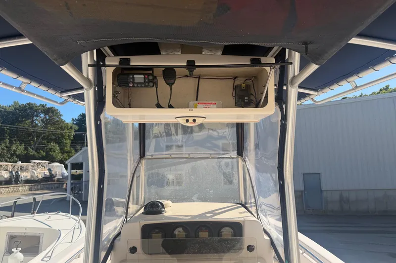 Slide: The Image of 2005 Grady-White Advance 257 boat interior with console and seating, docked outdoors. - 5