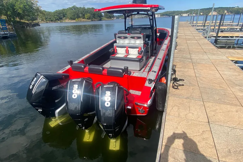 Slide: The Image of 2021 Fountain 34 SC boat docked, featuring triple Mercury 300 engines, vibrant red design. - 10