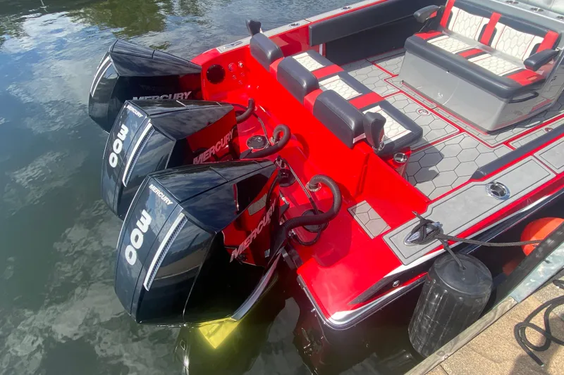 Slide: The Image of Red 2021 Fountain 34 SC boat with triple Mercury 300 engines docked on water. - 11