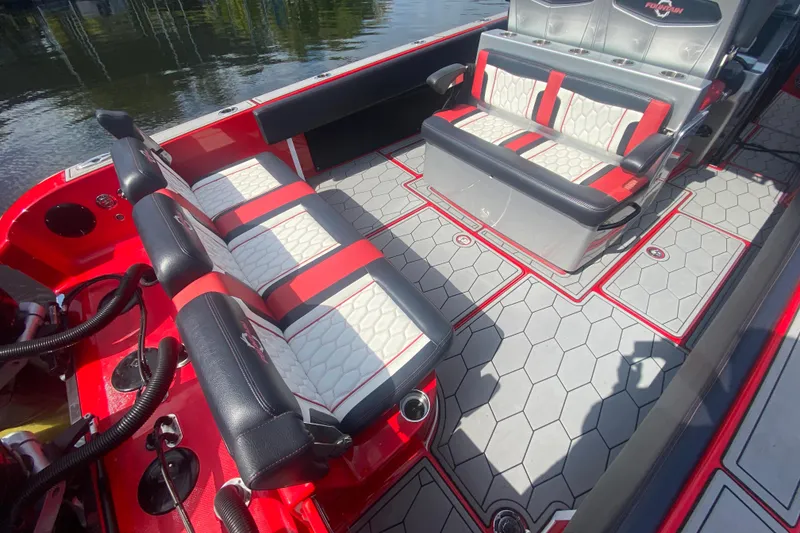 Slide: The Image of 2021 Fountain 34 SC boat interior with red and white seating, hexagonal flooring, and cup holders. - 12