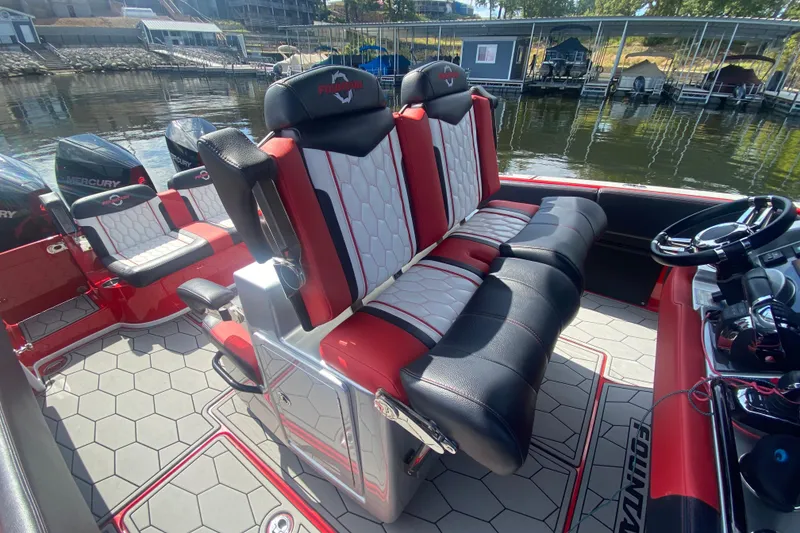 Slide: The Image of 2021 Fountain 34 SC boat interior with red and white seating, docked by the water. - 15