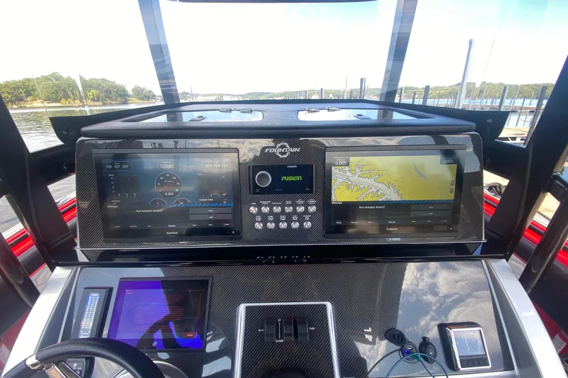 Slide: The Image of 2021 Fountain 34 SC boat dashboard with dual Garmin displays and navigation controls. - 19