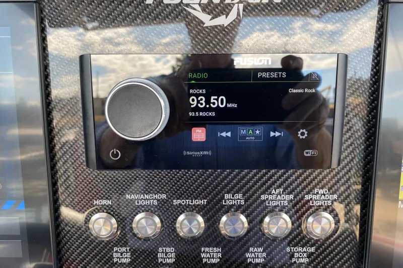 Slide: The Image of Carbon fiber dashboard of 2021 Fountain 34 SC with radio and control buttons. - 26