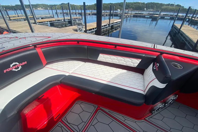 Slide: The Image of 2021 Fountain 34 SC boat interior with red and white seating at a marina. - 36