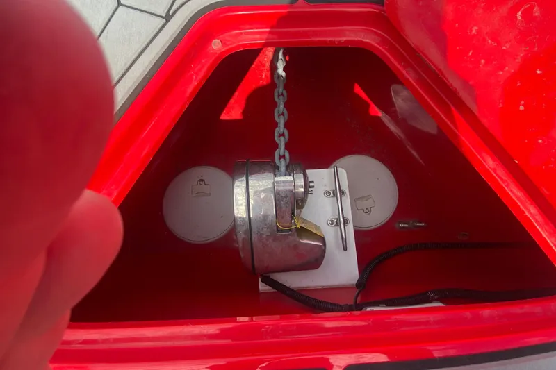 Slide: The Image of Anchor compartment of 2021 Fountain 34 SC boat with chain and red interior. - 38
