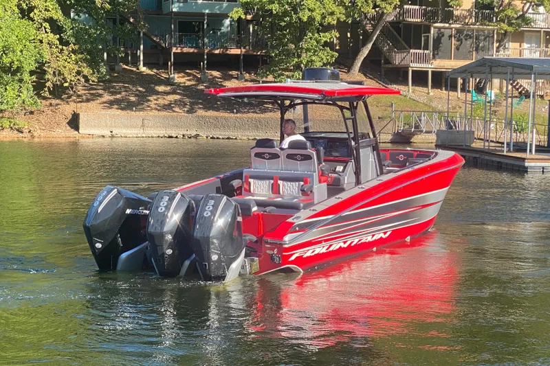 Slide: The Image of 2021 Fountain 34 SC boat with triple Mercury engines on a calm lake. - 9