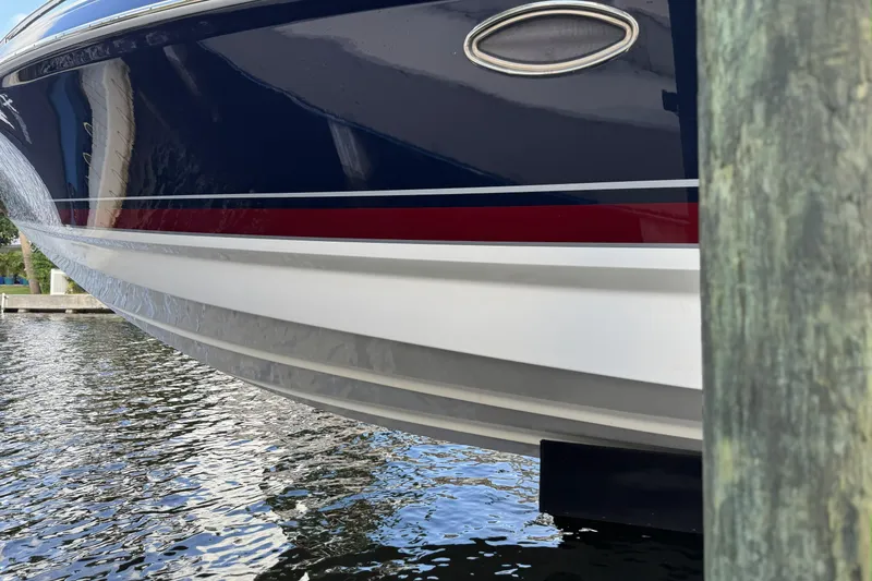 Slide: The Image of 2021 Formula 330 Crossover Bowrider OB boat hull near dock, reflecting on water. - 13