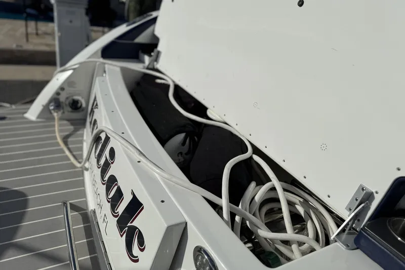 Slide: The Image of 2021 Formula 330 Crossover Bowrider OB with open storage compartment and coiled cables. - 18