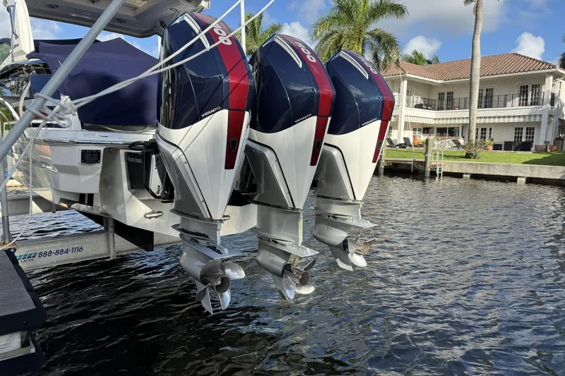Slide: The Image of 2021 Formula 330 Crossover Bowrider OB with triple outboard engines docked by waterfront home. - 2