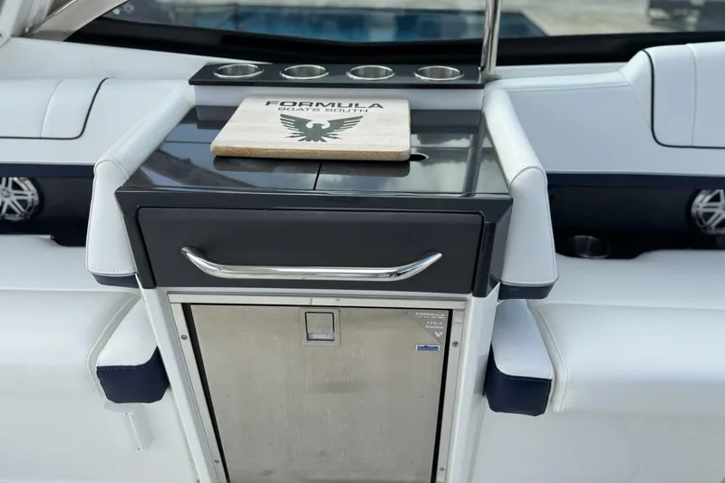Slide: The Image of 2021 Formula 330 Crossover Bowrider OB interior with sleek kitchenette and cutting board. - 26