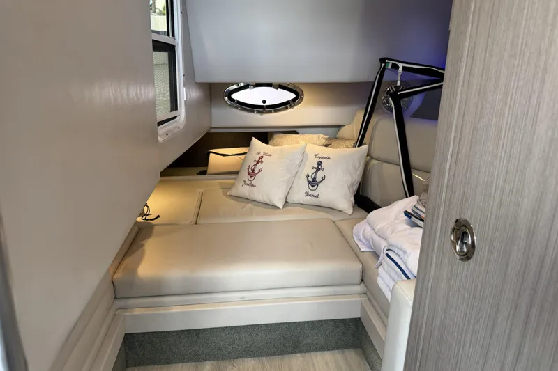 Slide: The Image of 2021 Formula 330 Crossover Bowrider OB cabin with cozy seating and nautical-themed pillows. - 50