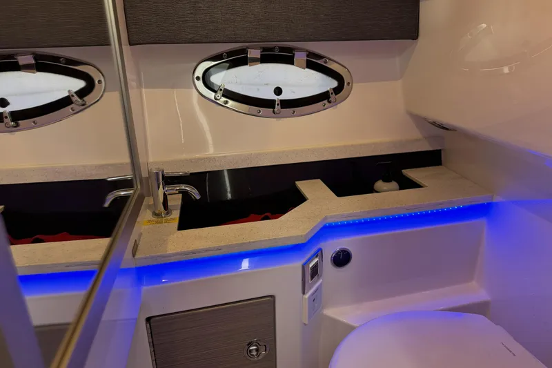 Slide: The Image of 2021 Formula 330 Crossover Bowrider OB bathroom with modern sink, mirror, and blue LED lighting. - 57