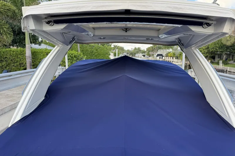 Slide: The Image of 2021 Formula 330 Crossover Bowrider OB with blue cover, docked outdoors. - 6