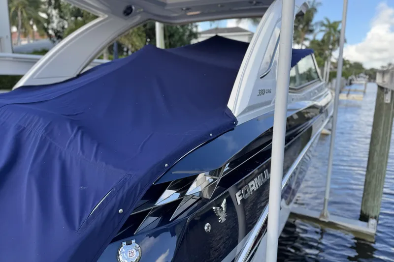 Slide: The Image of 2021 Formula 330 Crossover Bowrider OB covered, docked by the water. - 8