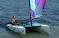 Slide: The Image of 2002 Hobie Cat Hobie Club Wave sailing on calm water with colorful sail. - 3