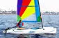 Slide: The Image of Colorful Hobie Cat Wave sailboat on water, 2002 model, vibrant sails, person sailing. - 6