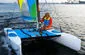 Slide: The Image of 2002 Hobie Cat Hobie Club Wave sailing on open water with colorful sails. - 8