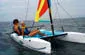 Slide: The Image of Two people sailing a 2002 Hobie Cat Hobie Club Wave on open water. - 9