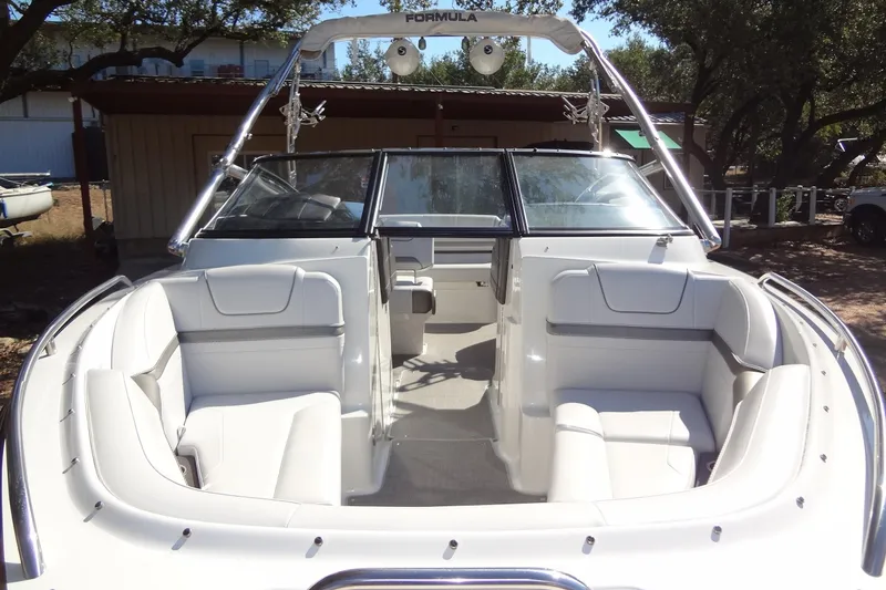 Slide: The Image of 2020 Formula 240 Bowrider boat on trailer, parked outdoors under trees. - 10