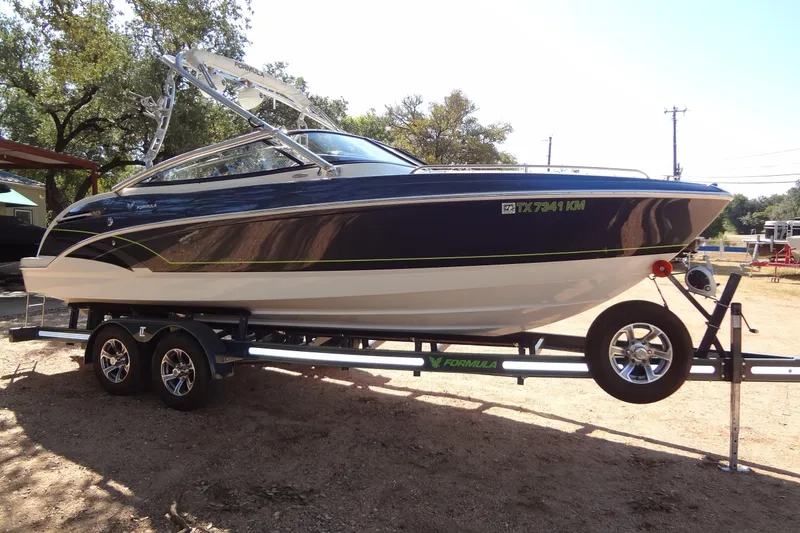 Slide: The Image of 2020 Formula 240 Bowrider boat on trailer, parked outdoors under trees. - 8