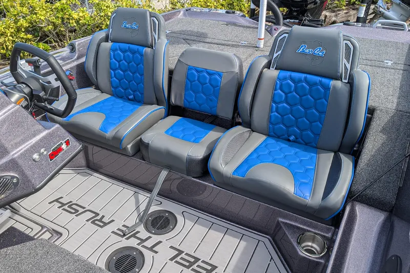 Slide: The Image of 2026 Bass Cat Eyra SP boat interior with blue and gray seats, steering wheel, and floor design. - 10