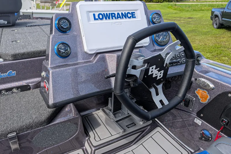 Slide: The Image of 2026 Bass Cat Eyra SP boat dashboard with Lowrance display and steering wheel. - 7