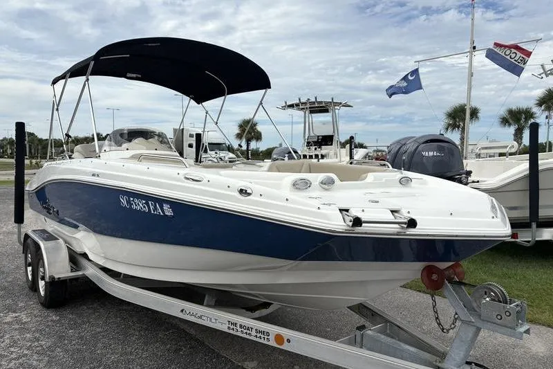 Slide: The Image of 2022 NauticStar 203 SC boat with canopy, parked outdoors on a cloudy day. - 10