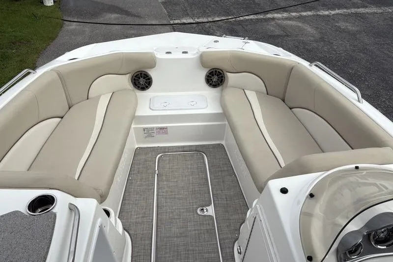 Slide: The Image of 2022 NauticStar 203 SC boat interior with beige cushioned seating and gray flooring. - 14