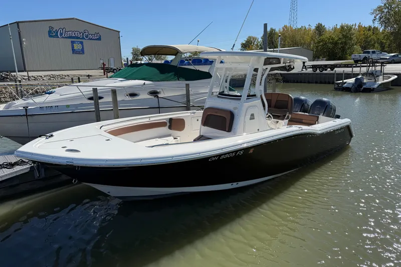 Slide: The Image of 2017 Tidewater 252 CC Adventure boat docked at marina, sunny day. - 0