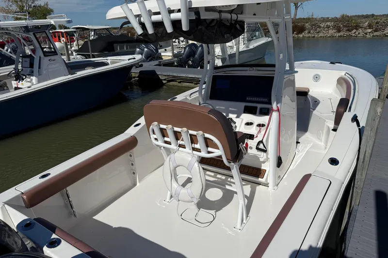 Slide: The Image of 2017 Tidewater 252 CC Adventure boat docked, featuring spacious deck and modern console. - 3
