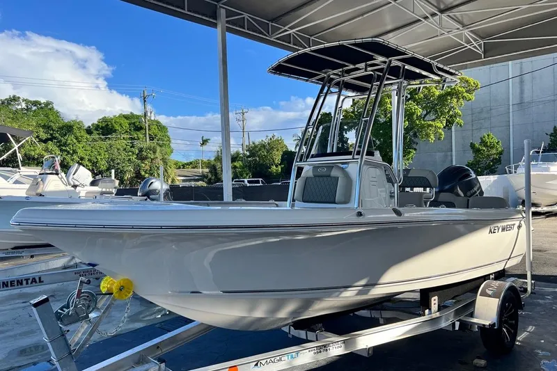 Slide: The Image of 2026 Key West 189 FS boat on trailer under canopy, sunny day. - 1