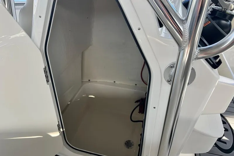 Slide: The Image of 2026 Key West 189 FS boat storage compartment with open door and stainless steel railing. - 24