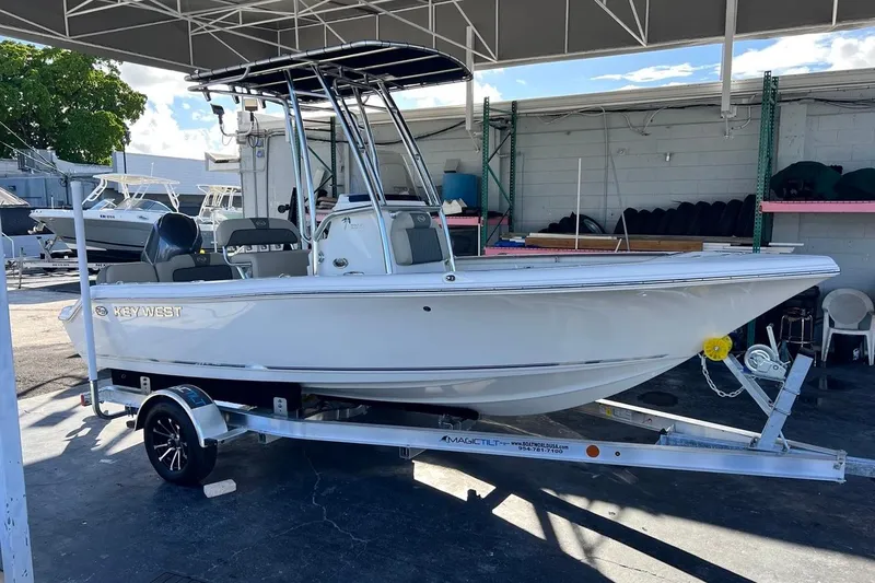 Slide: The Image of 2026 Key West 189 FS boat on trailer under canopy, parked in a marina. - 3