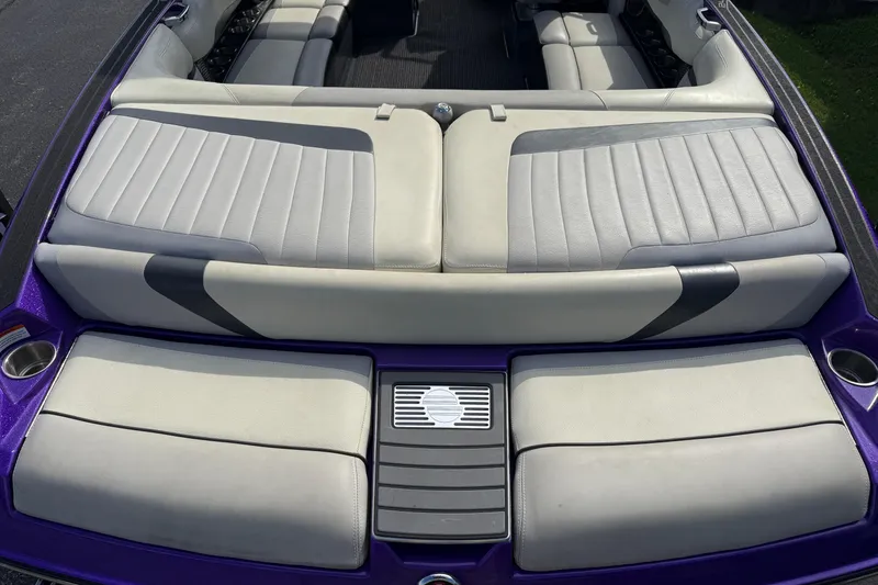 Slide: The Image of 2015 Malibu Wakesetter 24 MXZ boat interior with gray seating and purple accents. - 11