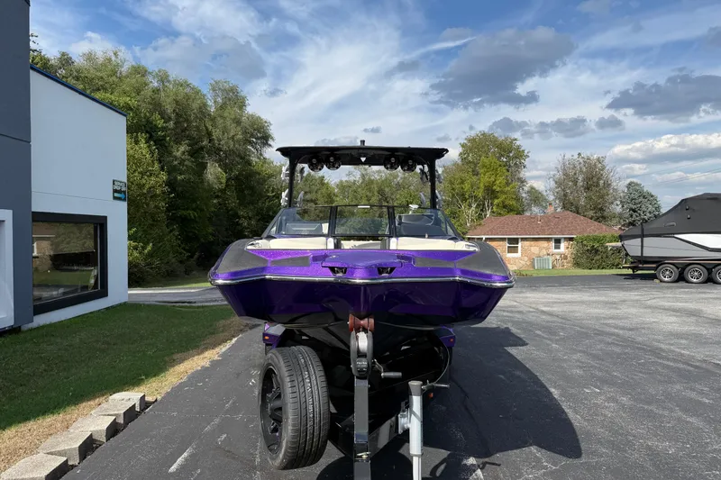 Slide: The Image of 2015 Malibu Wakesetter 24 MXZ boat in vibrant purple on a trailer, outdoors. - 2